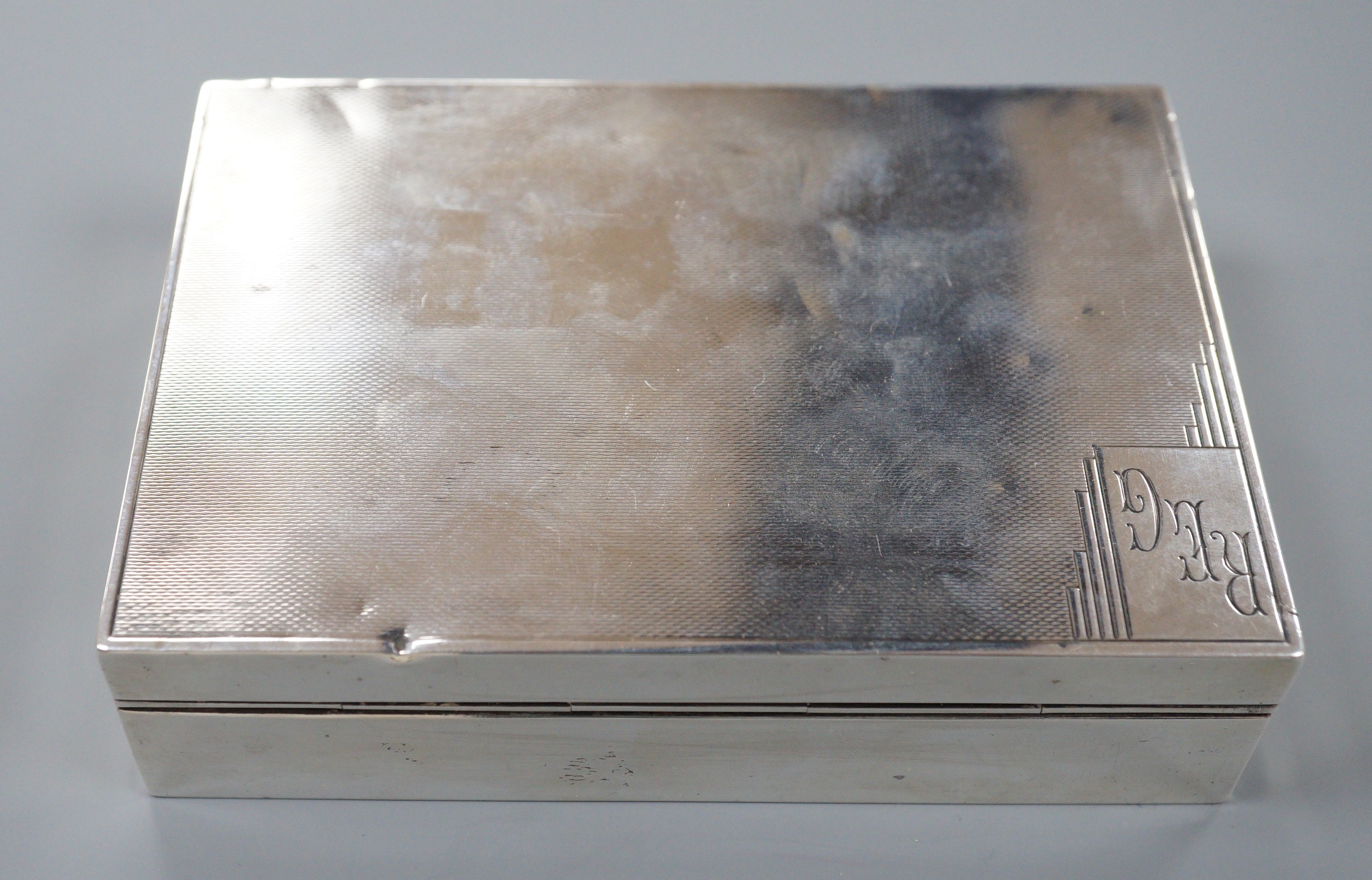 A George V engine turned silver rectangular cigarette box, Mappin & Webb, London, 1933, 12.8cm.